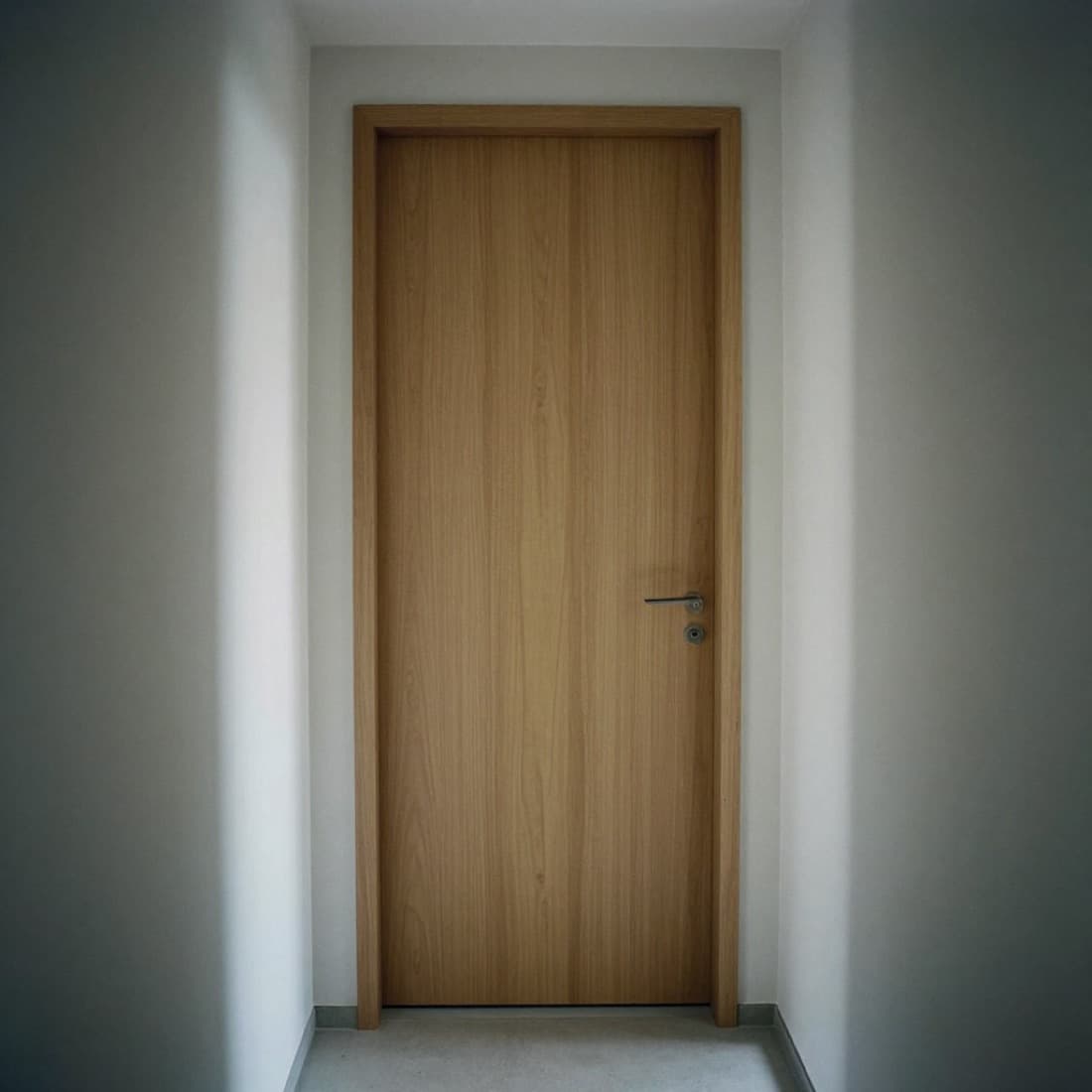 Innentür in heller Eiche mit schlichtem Drücker in einer hellen Wand